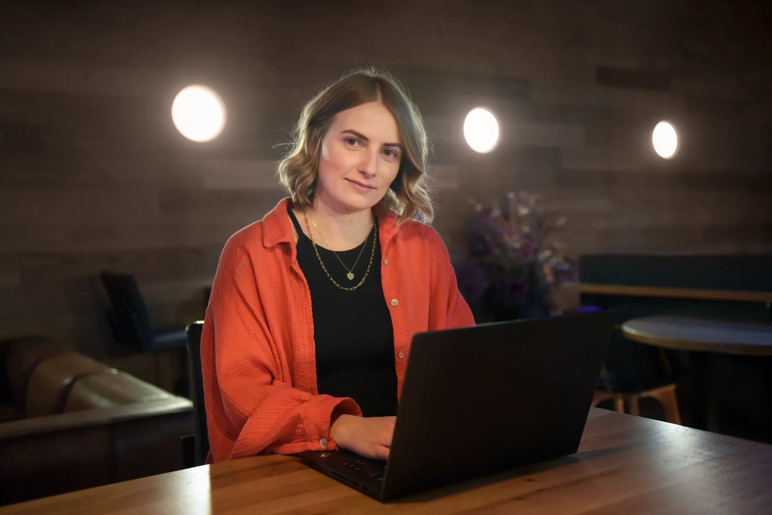 Frau arbeitet vor stilvoller Einrichtung am Laptop