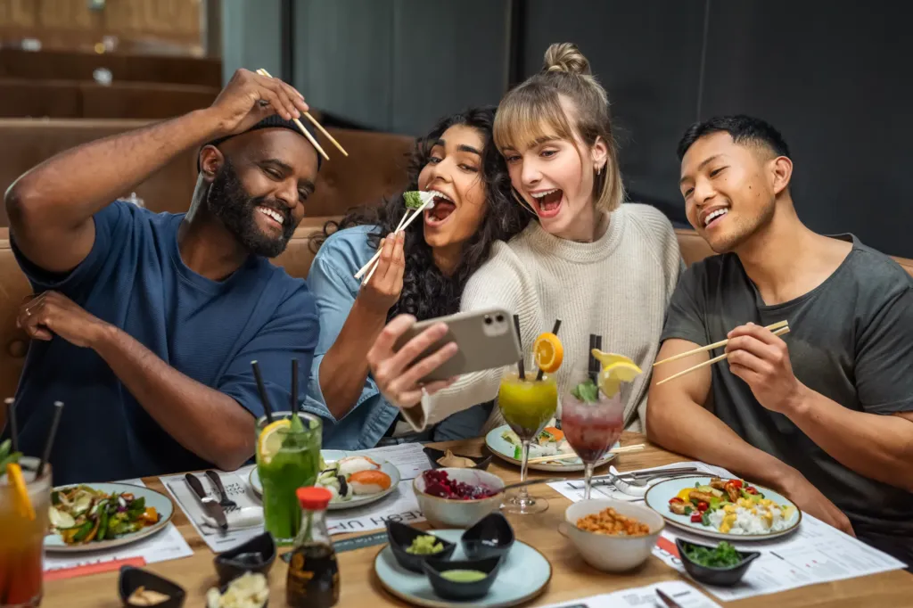 Freunde machen Selfies mit ihrem Sushi, Grillteller und Asia Curry vom Buffet