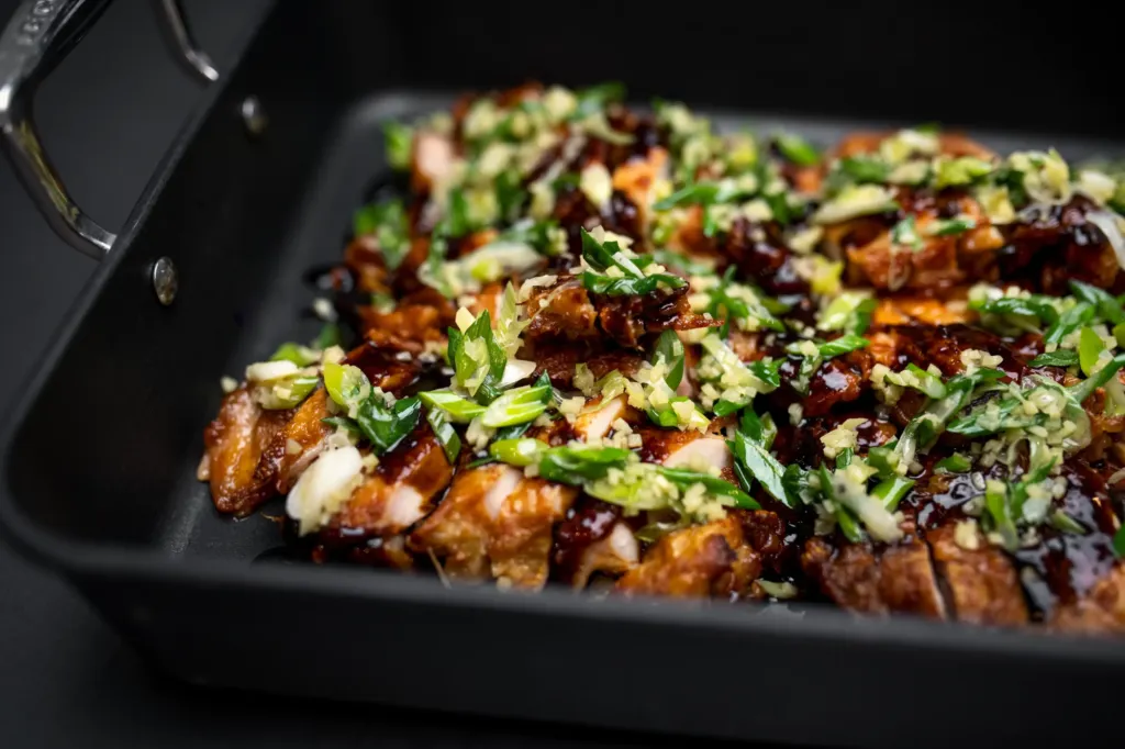 Knuspriges gegrilltes Fleisch mit Sauce und Kräutern