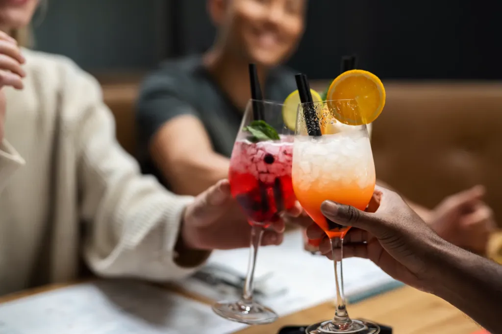 Freunde stoßen mit Wildberry-Lillet und Aperol-Spritz an