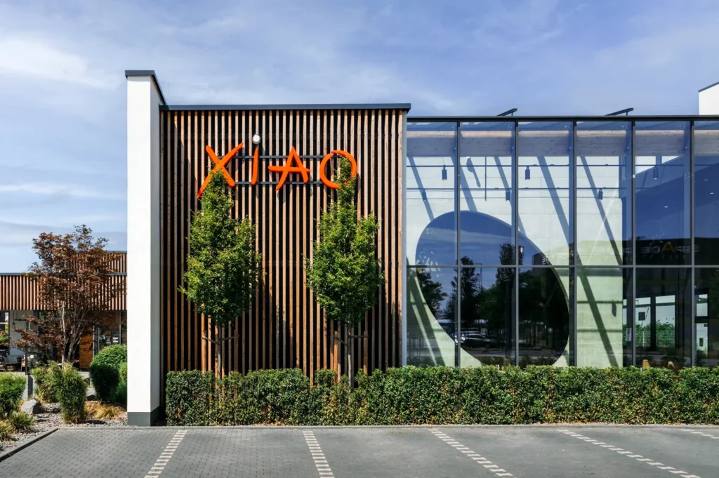 Ein modernes Glasgebäude mit XIAO-Logo und Parkplatz