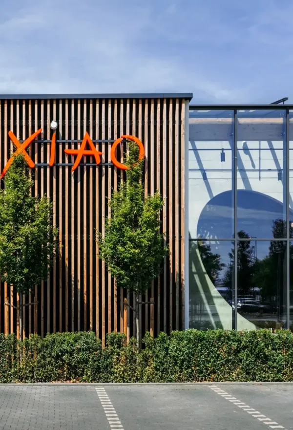 Ein modernes Glasgebäude mit XIAO-Logo und Parkplatz