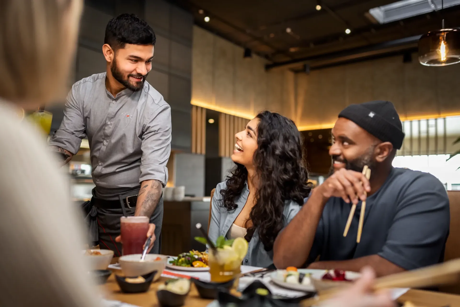 Servicekraft bringt Freundesgruppe einen Cocktail
