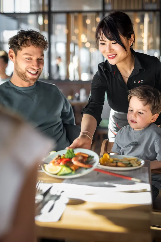 Einer Familie wird asiatisches Essen an den Tisch gebracht