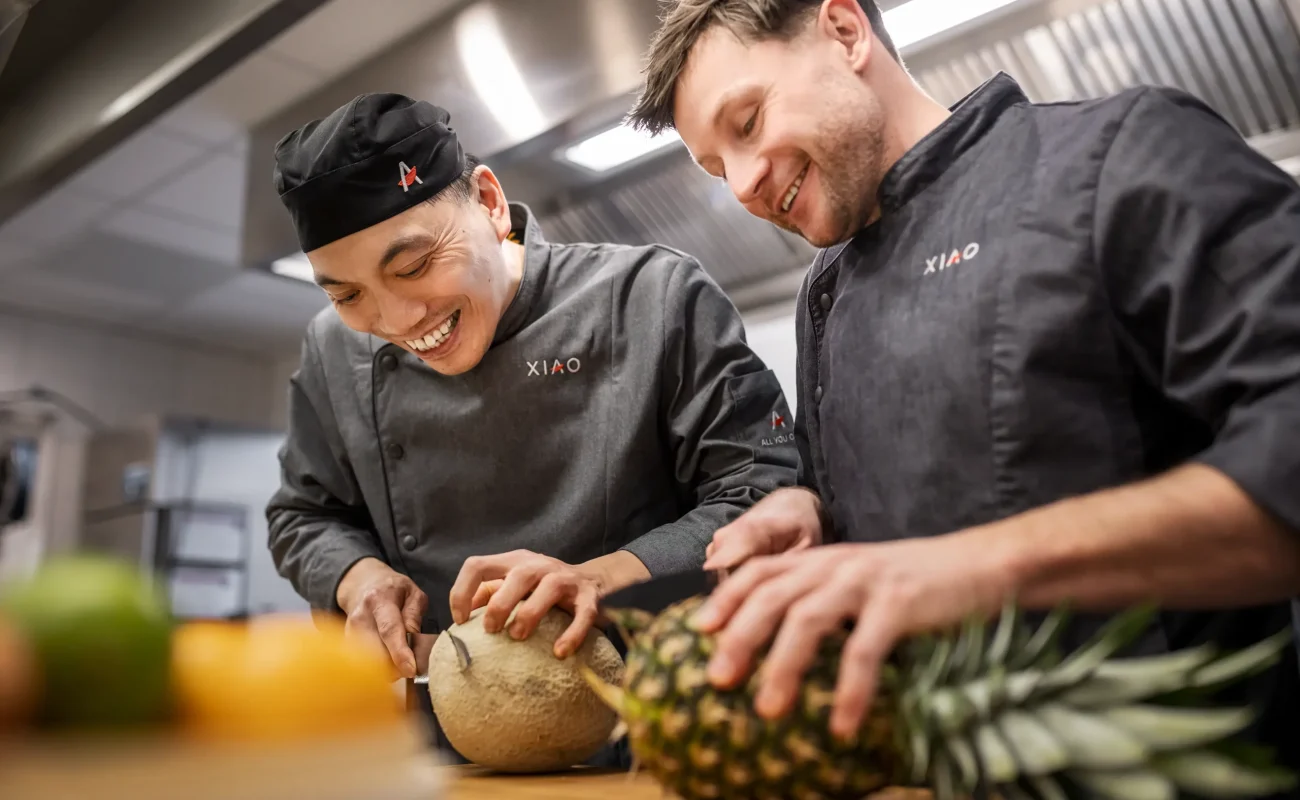Köche schneiden Obst Zwei XIAO Mitarbeiter schneiden frisches Obst in der Gastro Küche