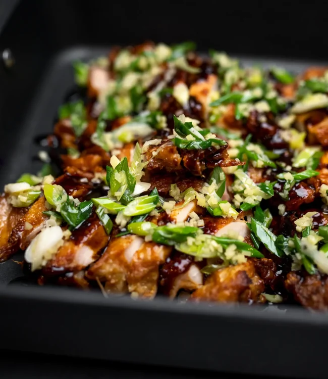 Gegrilltes Fleisch Knuspriges gegrilltes Fleisch mit Sauce und Kräutern