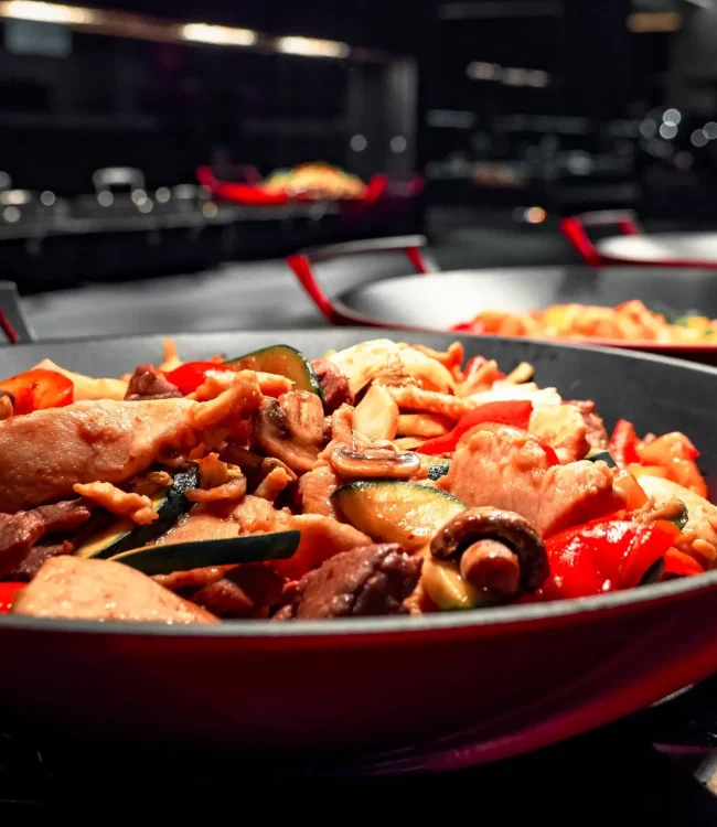 xiao-wok-food Mehrere Pfannen, gefüllt mit buntem Gemüse und Fleisch.